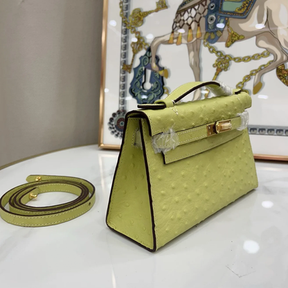 Bright Budding Lime Yellow Uniform Raised Dot Slim Horizontal Rectangular Carry Bag With Polished Golden Twist Lock Hardware And Single Short Curved Top Grip